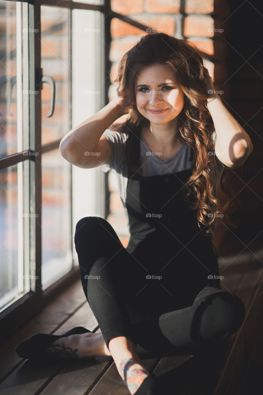 Portrait of young beautiful woman near window