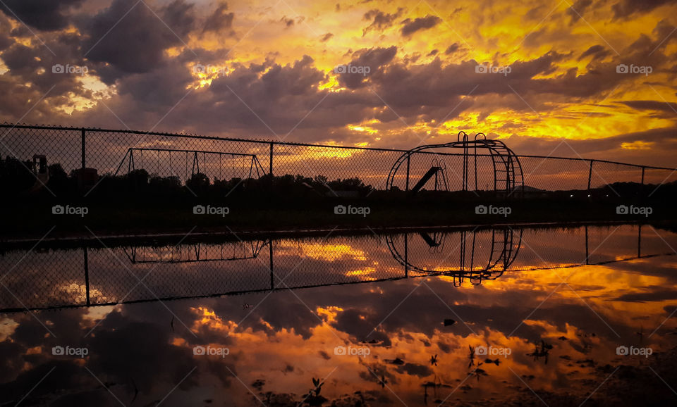 Reflection of a playground mirrored in a puddle, after the storm.