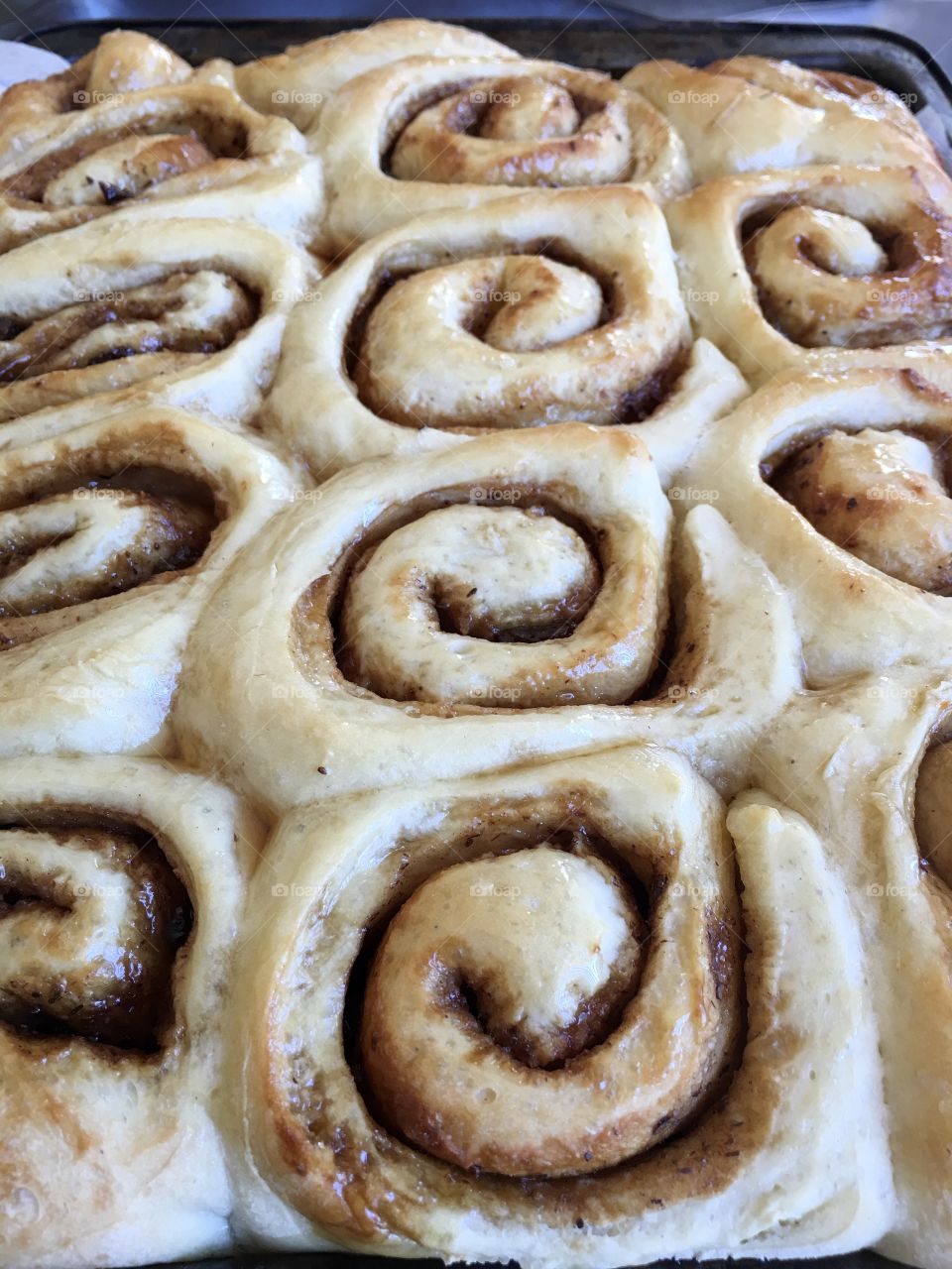 Background or closeup image home baked cinnamon rolls scrolls topped with maple syrup glaze