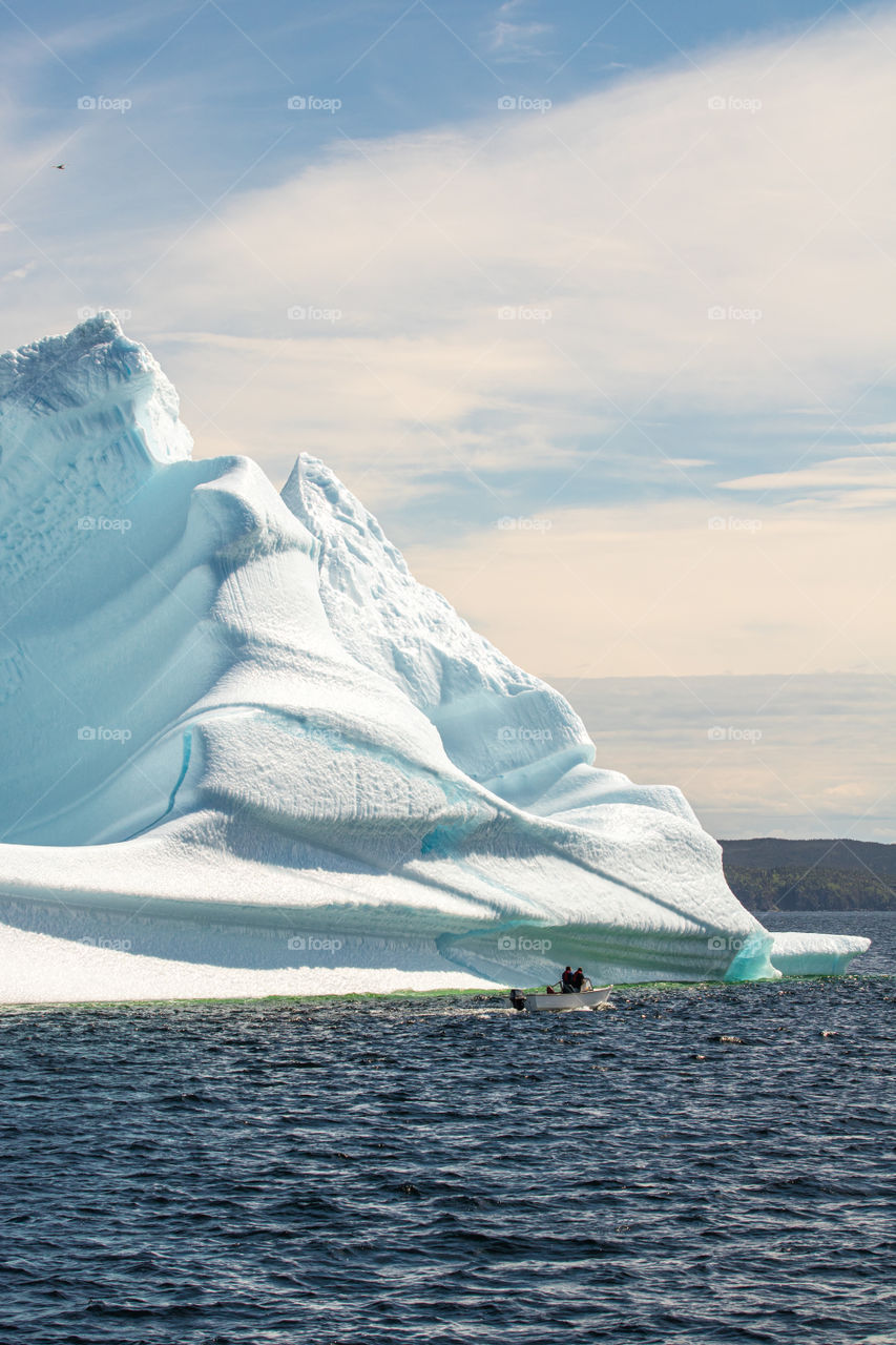 People on a boat checking out a huge iceberg making its way down the east coast of Newfound, appropriately named ‘Iceberg Alley’, one of the provinces amazing attractions.  