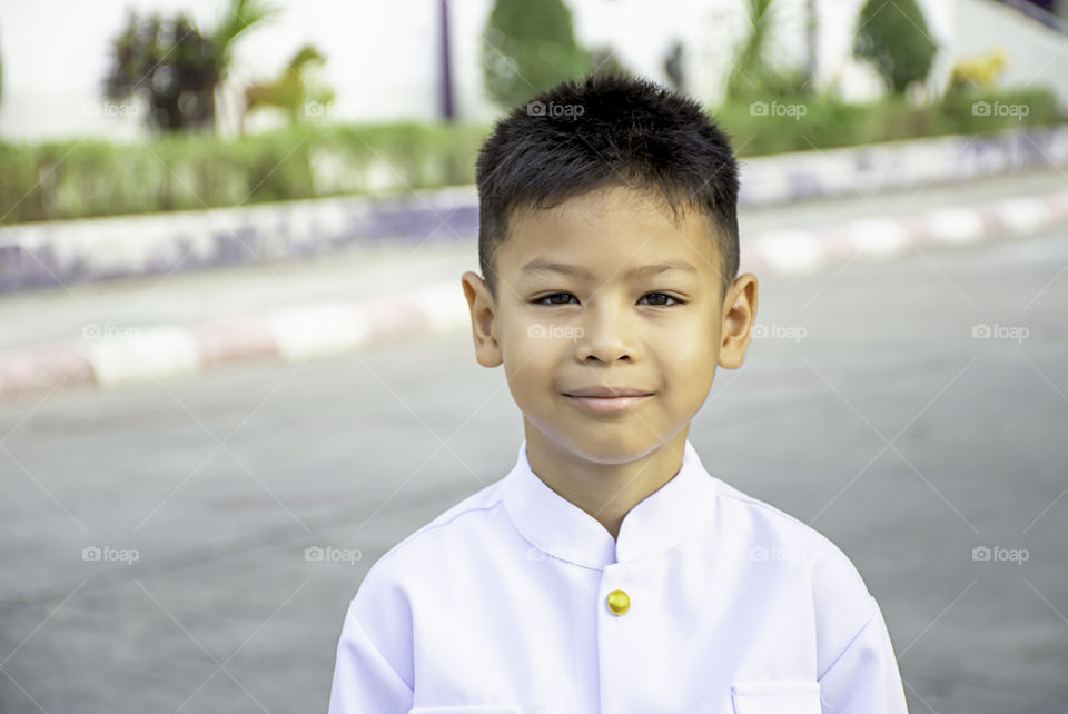 Portrait of Asian boy Wearing a white shirt on the road.