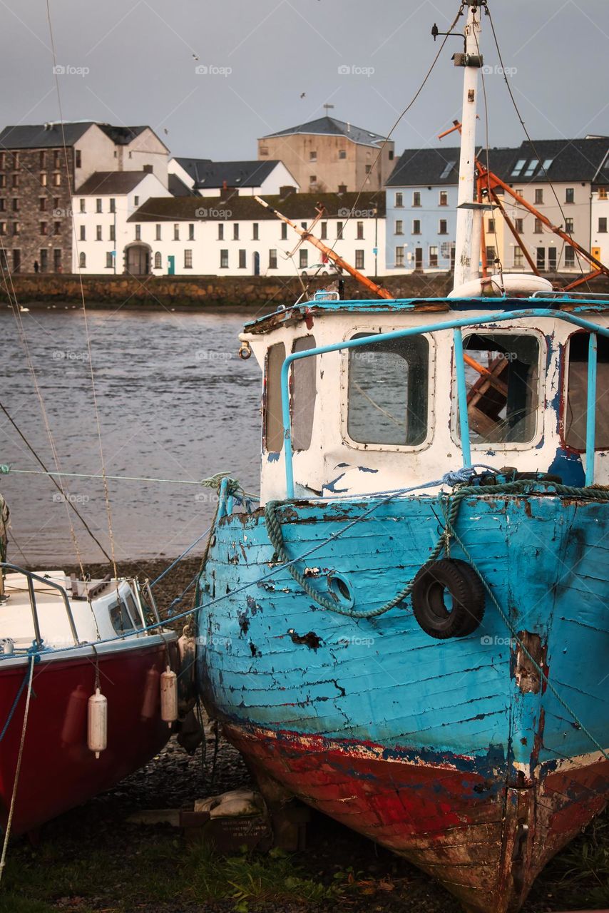 Old blue wooden boat on the Corrib River shore at Claddagh, Galway City, Ireland