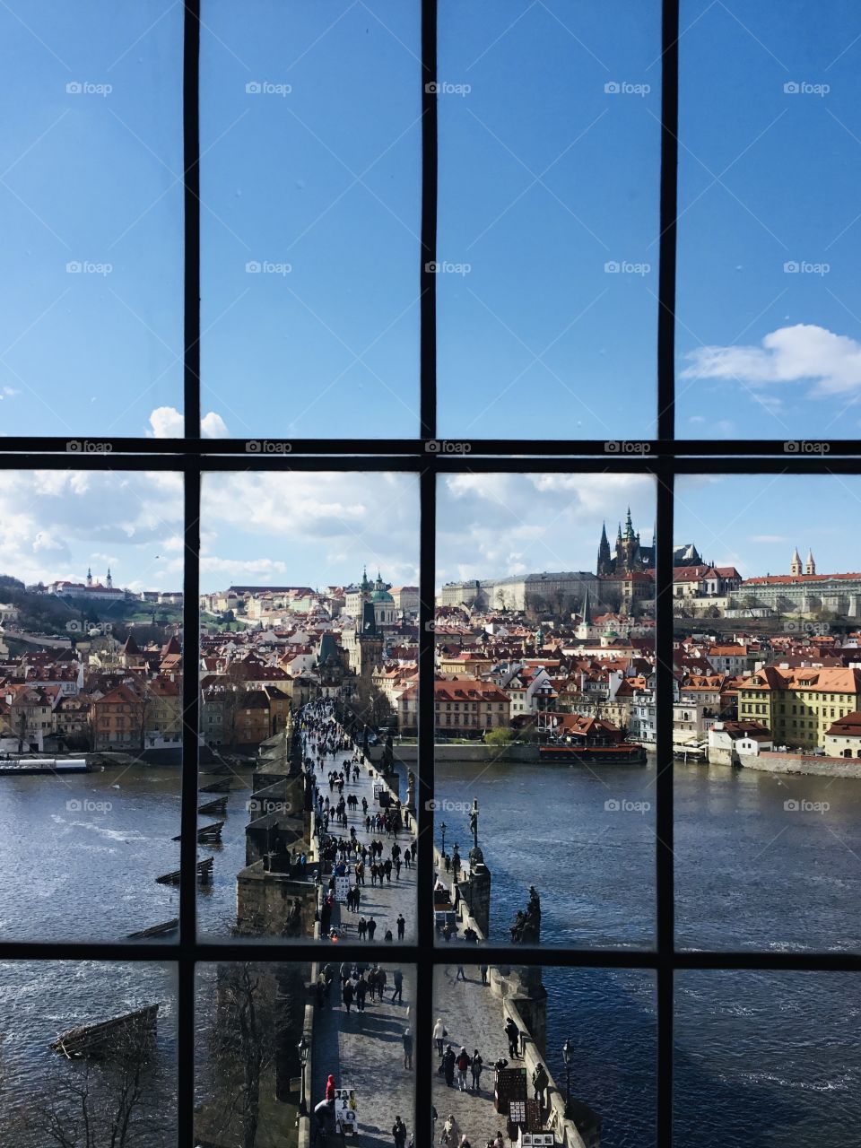 View from the window. St. Charles Bridge. Framing the photo draws focus to the subject in the photo by blocking other parts of the image with something in the scene