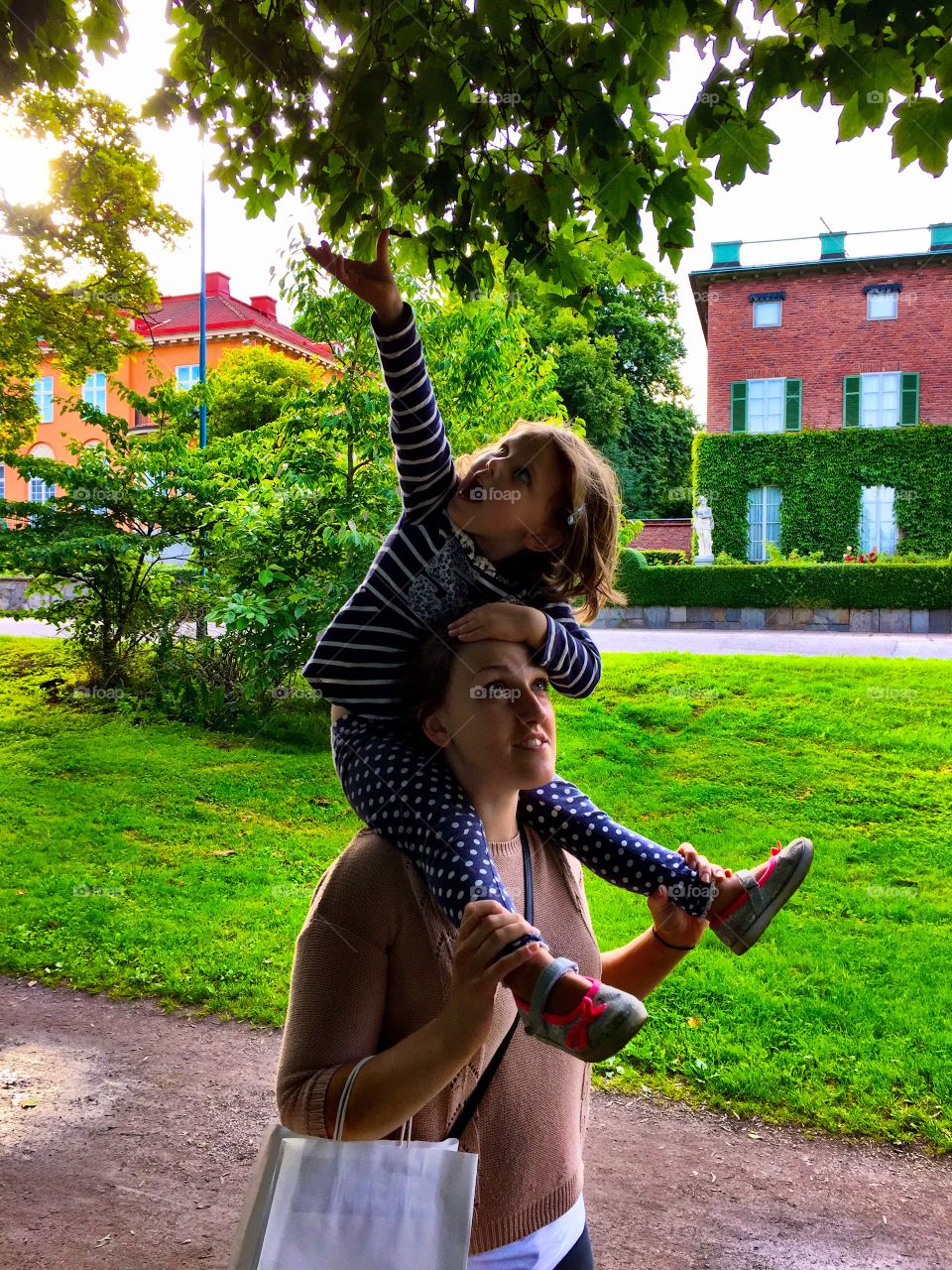 Woman carrying her daughter on shoulder