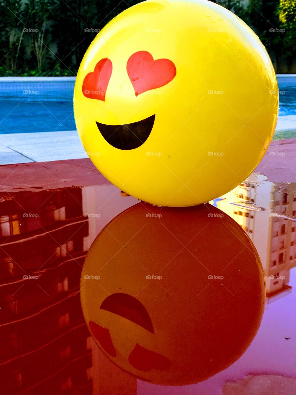 Yellow smile ball reflecting on the red floor