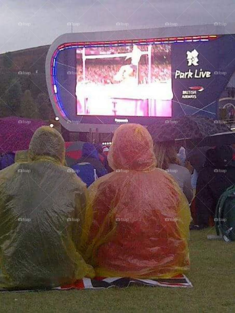 people watching the big screen at London 2012 Olympics in the rain