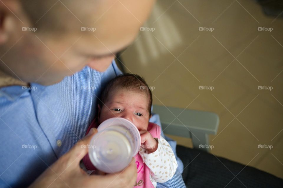 hungry baby and dad gives her bottle