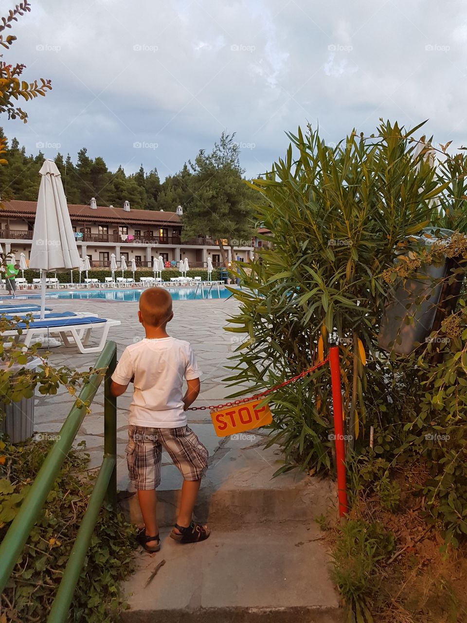 small boy in front of the pool. summer time