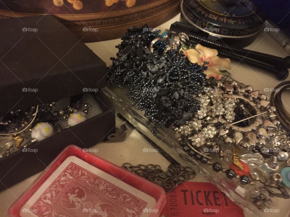 Jewelry and miscellaneous stuff piled on a dresser.
