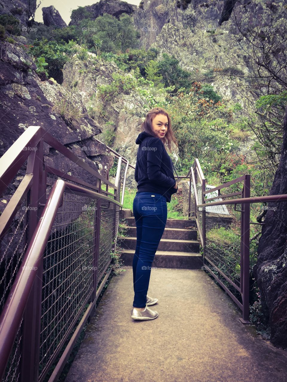 Woman standing on path in front of mountain