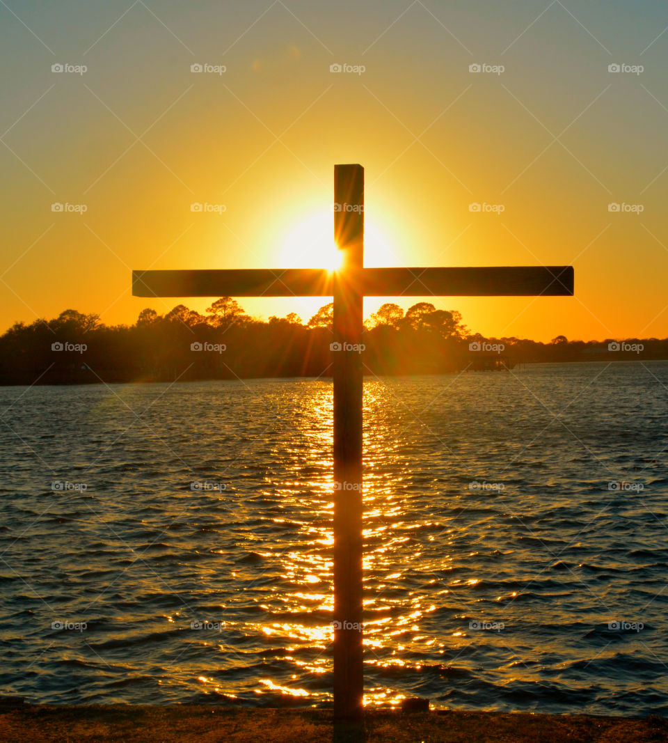 Beautiful sunrise behind cross