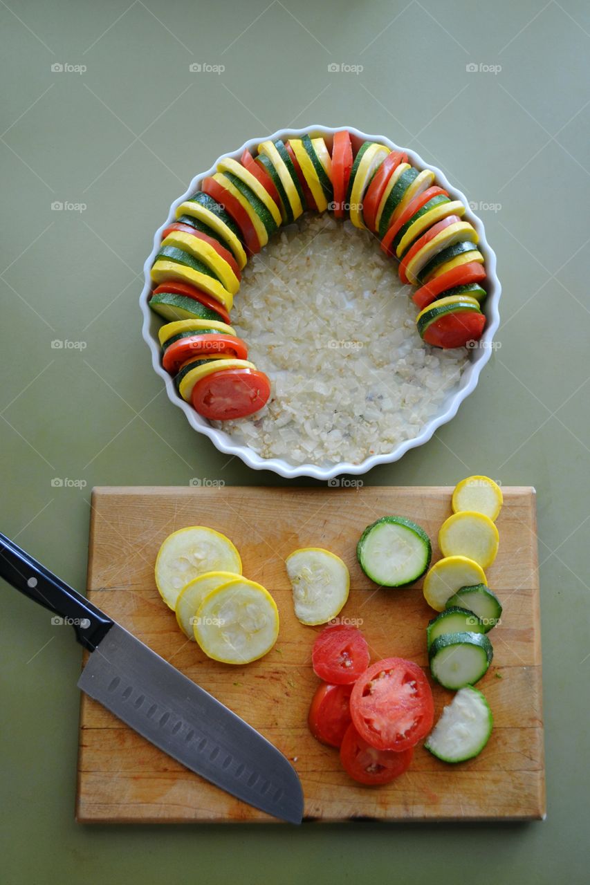 Vegetable Tian of tomato, zucchini, summer or yellow squash and potato slices arranged on a bed of onions