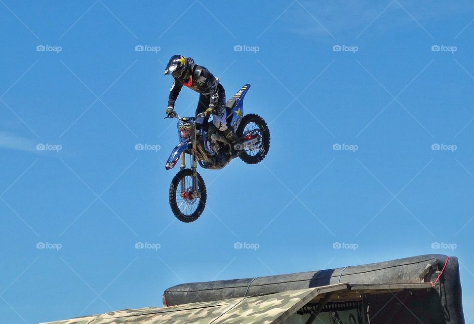 Motorcycle Stunt. Expert Rider Jumping A Motorcycle Off A Ramp
