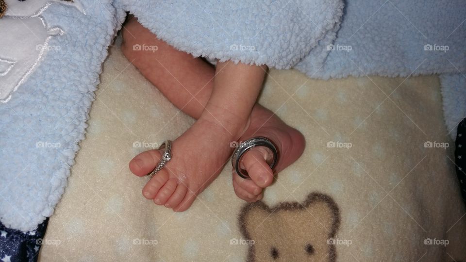 Wedding rings on baby's feet.