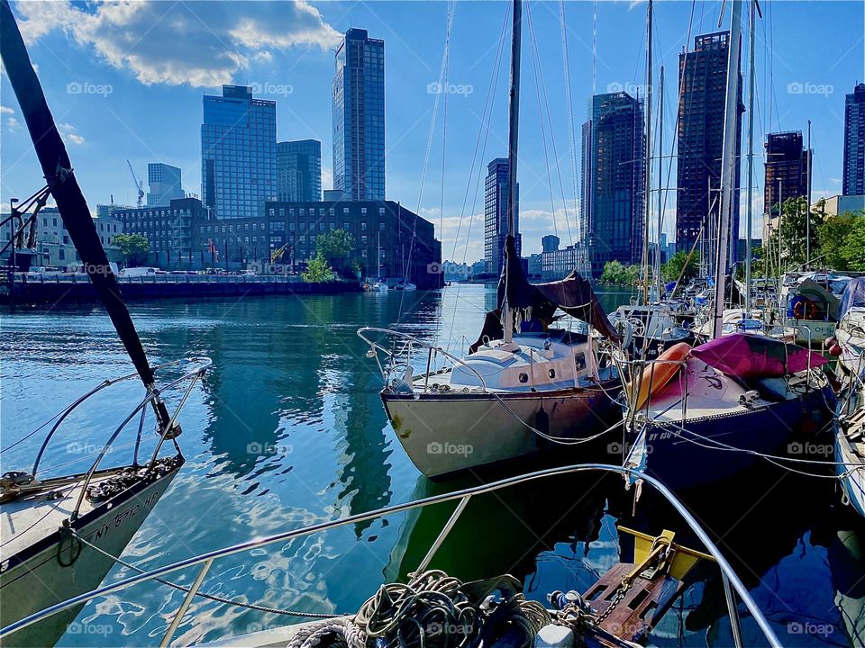 This is “Newtown Creek” by the “Pulaski Bridge” in LIC, Queens. All types of boats are tied up here and the views go around the boroughs. On the left we see “Greenpoint”, Bklyn, straight ahead and to the right “Manhattan”. 2023. Hypnotic Productions