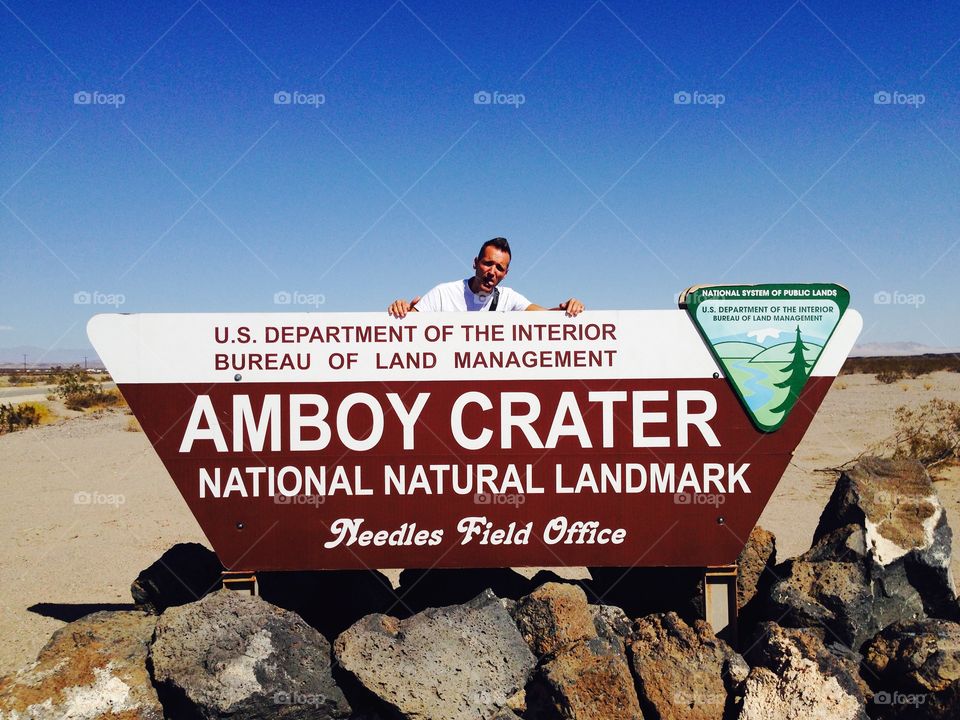 Happy man behind  the Amboy Crater sign