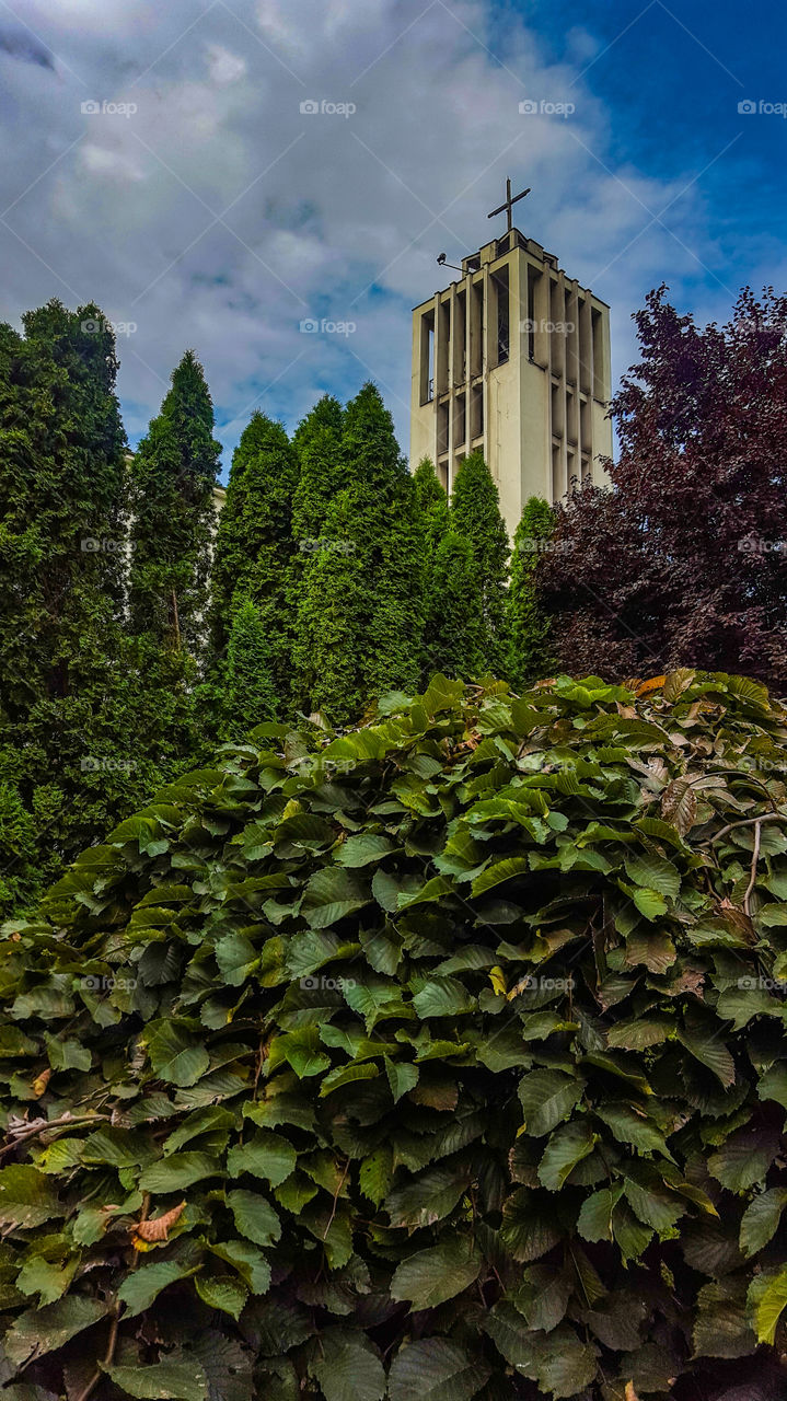 modernist church tower among greenery