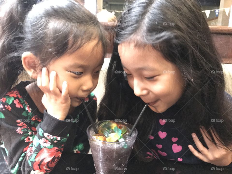 Sisters sharing a frozen treat