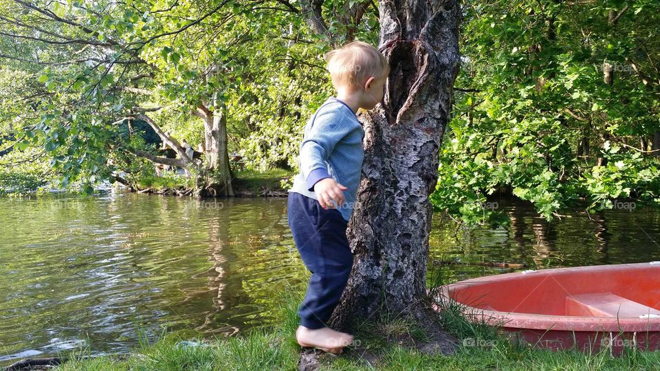 Curious boy peeking in to hole in three