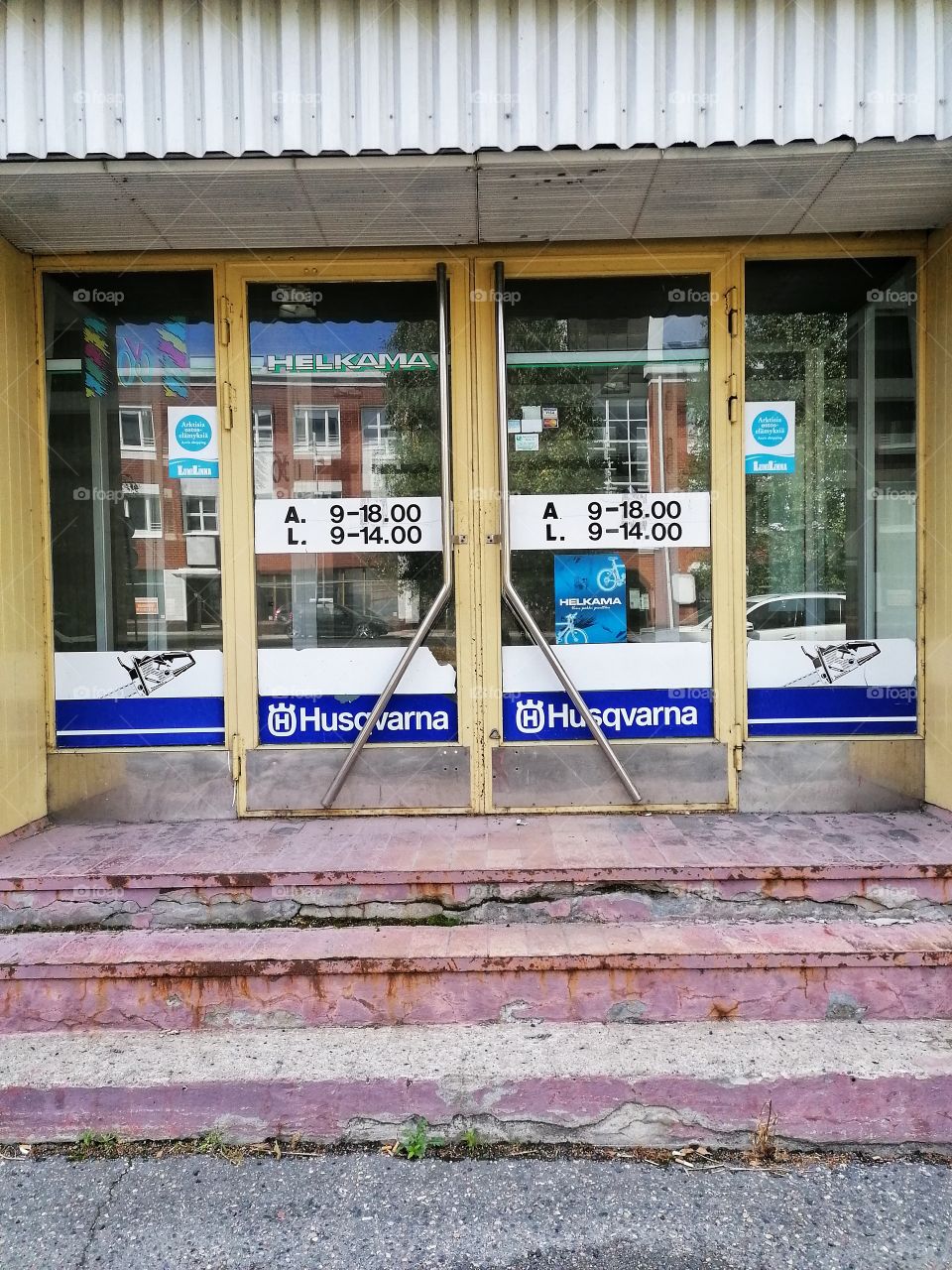 An old dilapidated building in the middle of a town that used to be a shop. No one walks through these doors anymore. Sad.