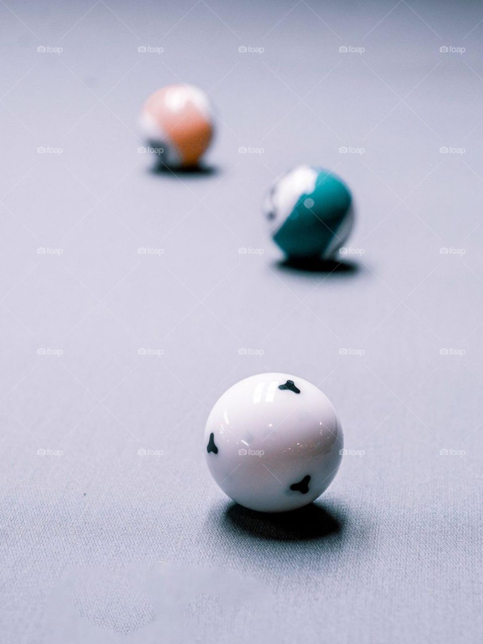 Close-up view of three colored balls placed on a gray flat surface