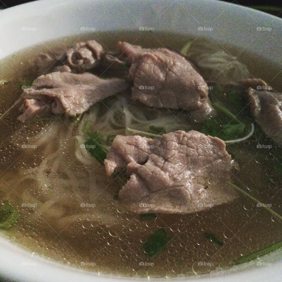 Close up beef pho with noodles and vegetables