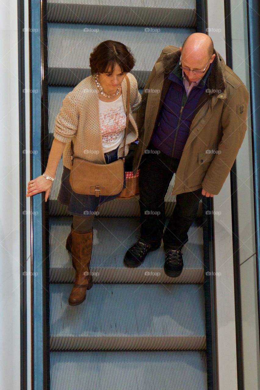 Couple on escalator in shopping mall
