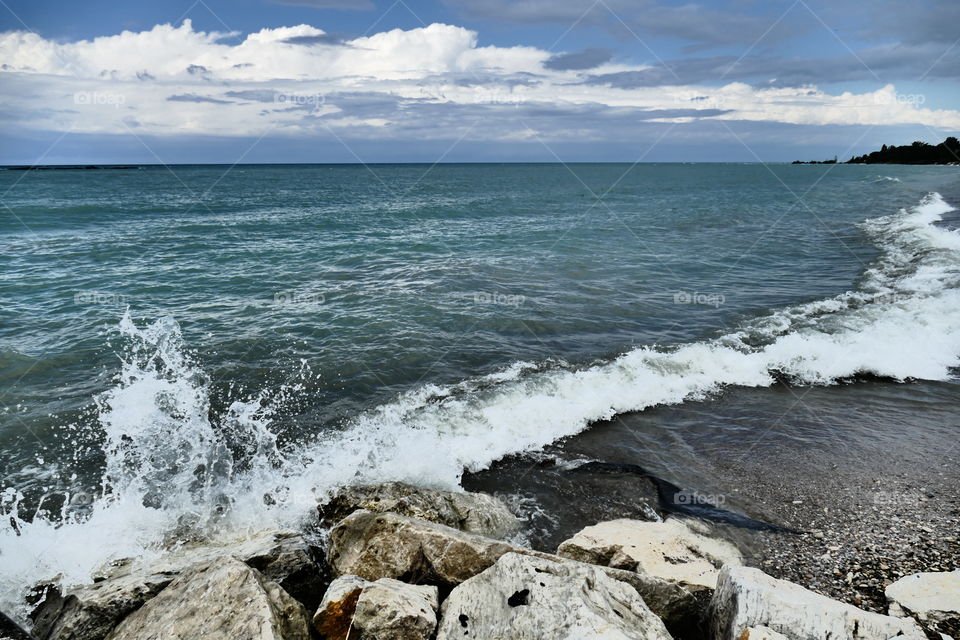 Waves crash over the rocks at Kincardine Beach. Ontario, Canada.