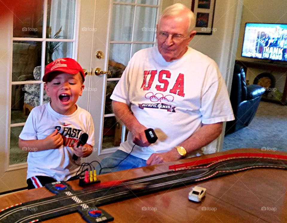 Grandfather and grandson playing with toy car
