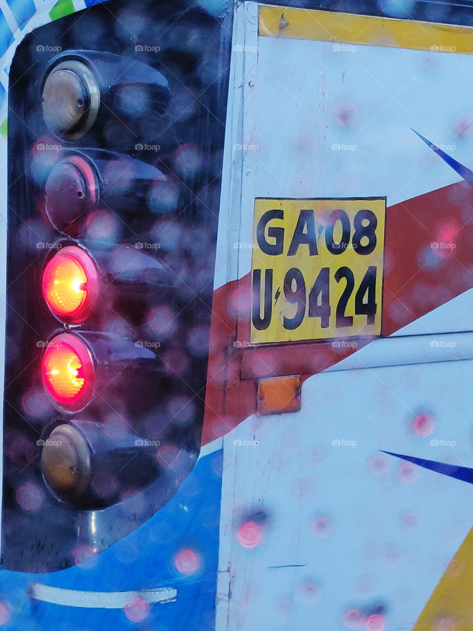 circular backlights of a local Transport bus captured thru the car window in rain