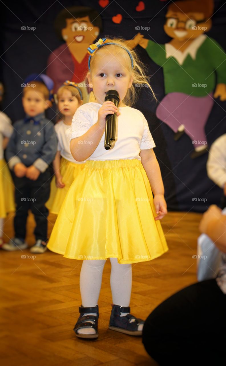 Little girl standing with holding mike in hand