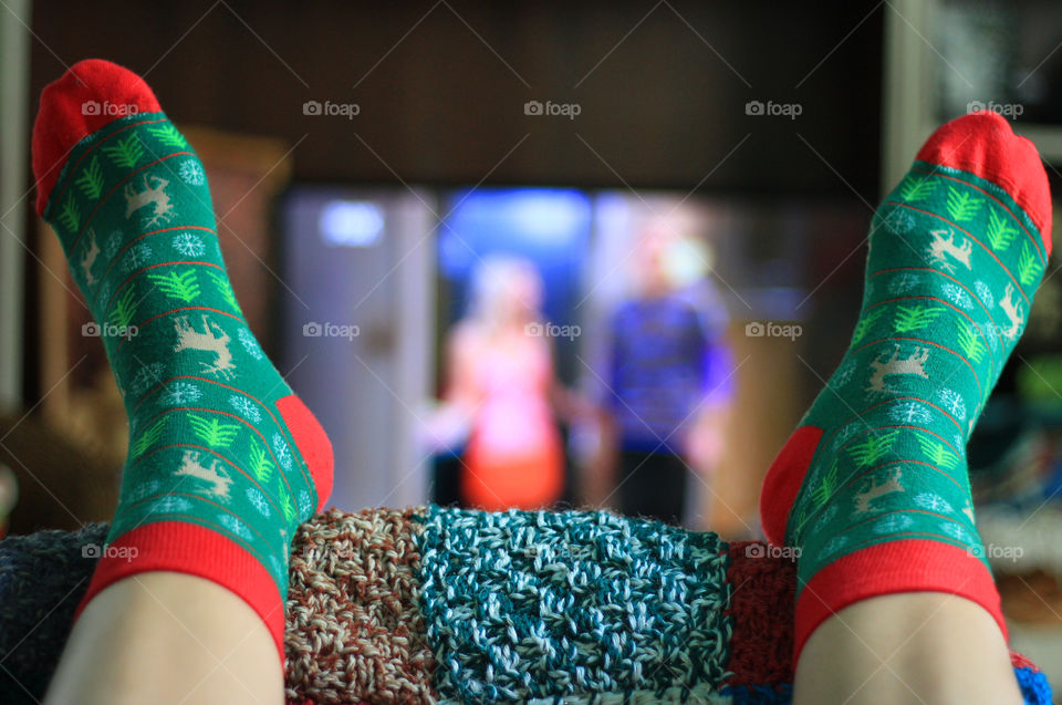 Christmas at home, cozy time, watching television, legs up on the chair, Christmas decorated socks