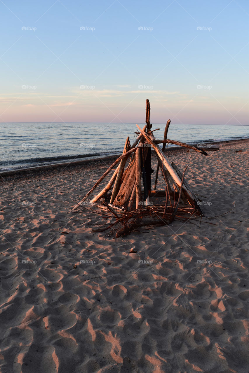 Wood for a bonfire on the beach at sunset