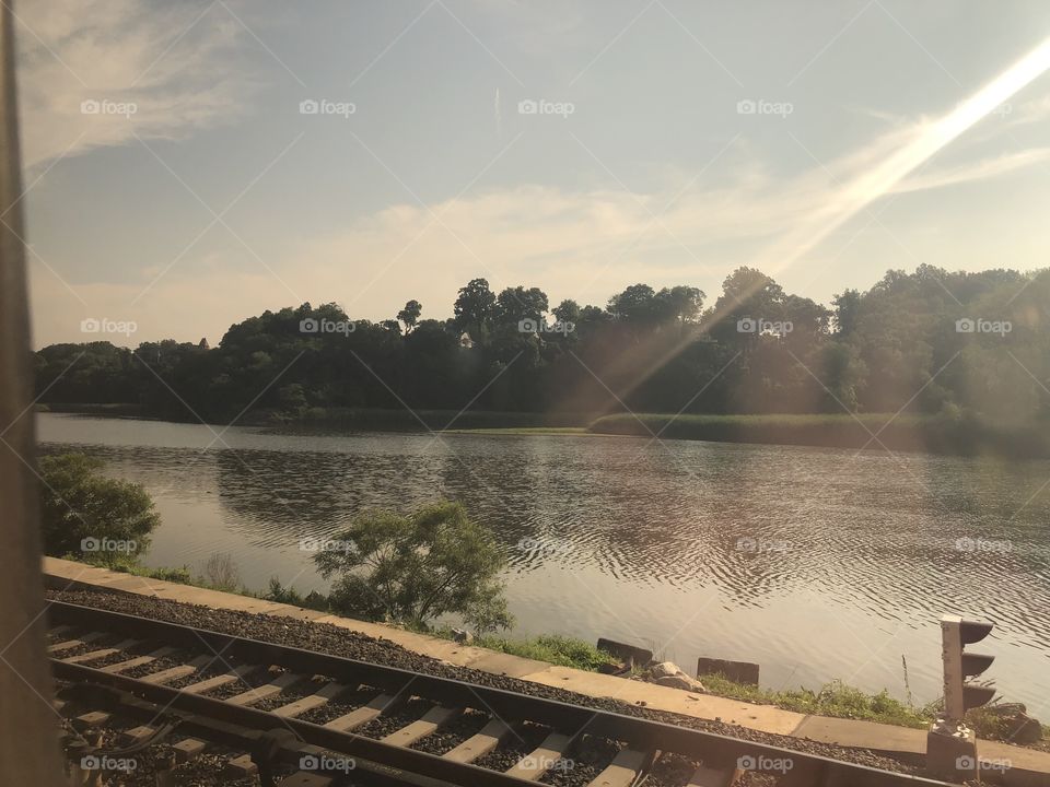 Sun shining on the train tracks over the river