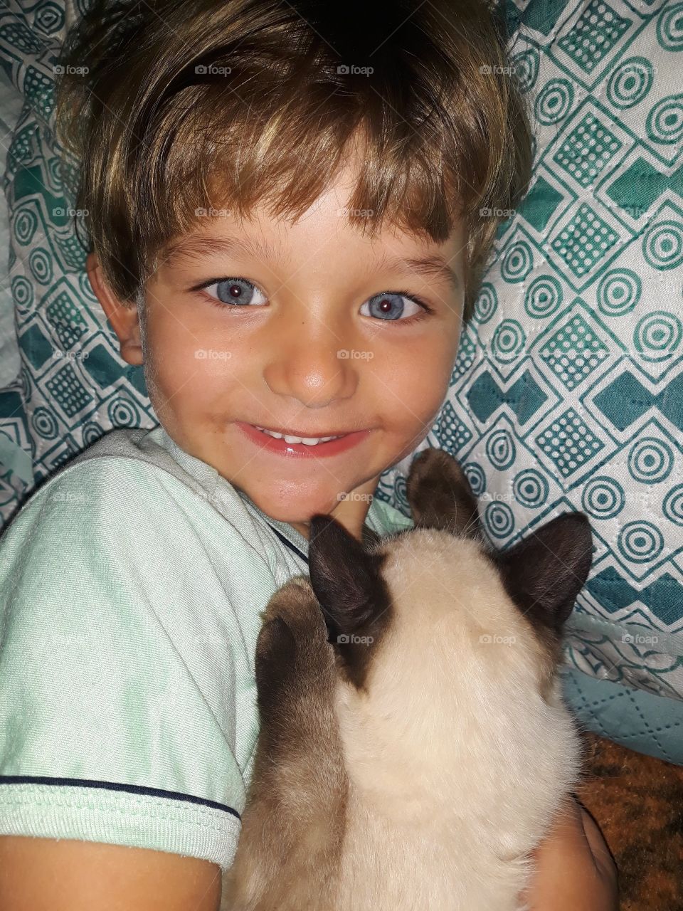 smiling child lying with the cat
