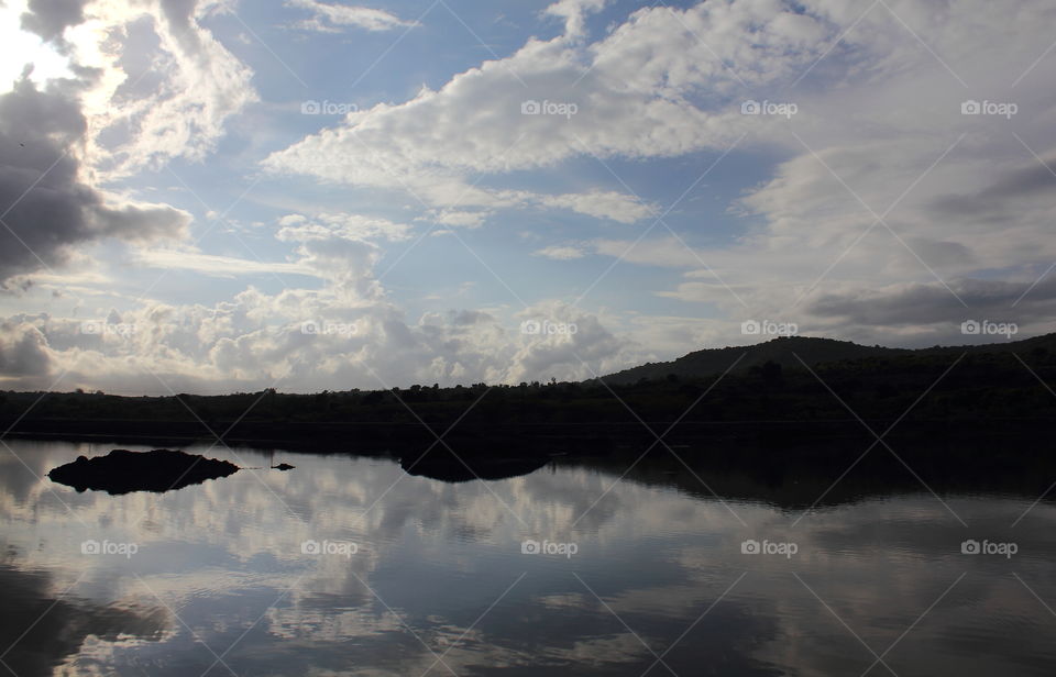 Reflection. Clear blue sky with the beauty creatured of white . Fish pound of estuarya landscape shown the geography well for the mountain.