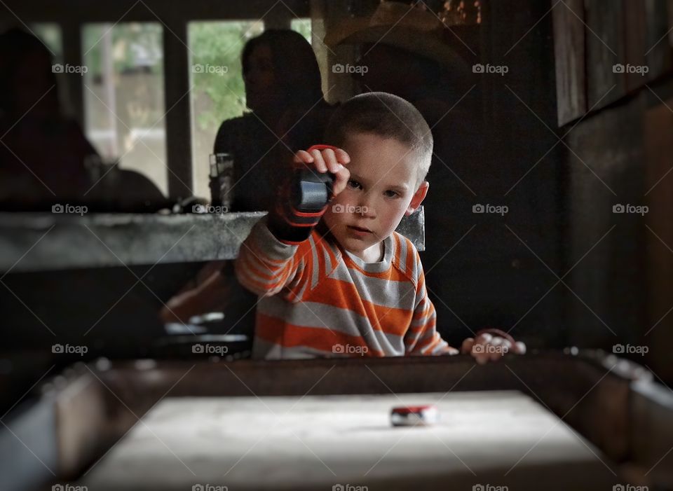 Shuffleboard . Boy Playing Indoor Shuffleboard
