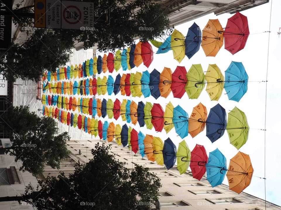 Colorful umbrellas on top of a lively street in Liverpool, England.