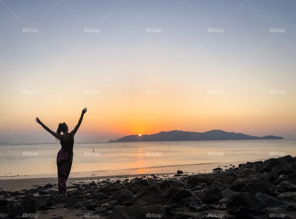 Silhouette of young female person enjoy on beautiful beach at sunset 