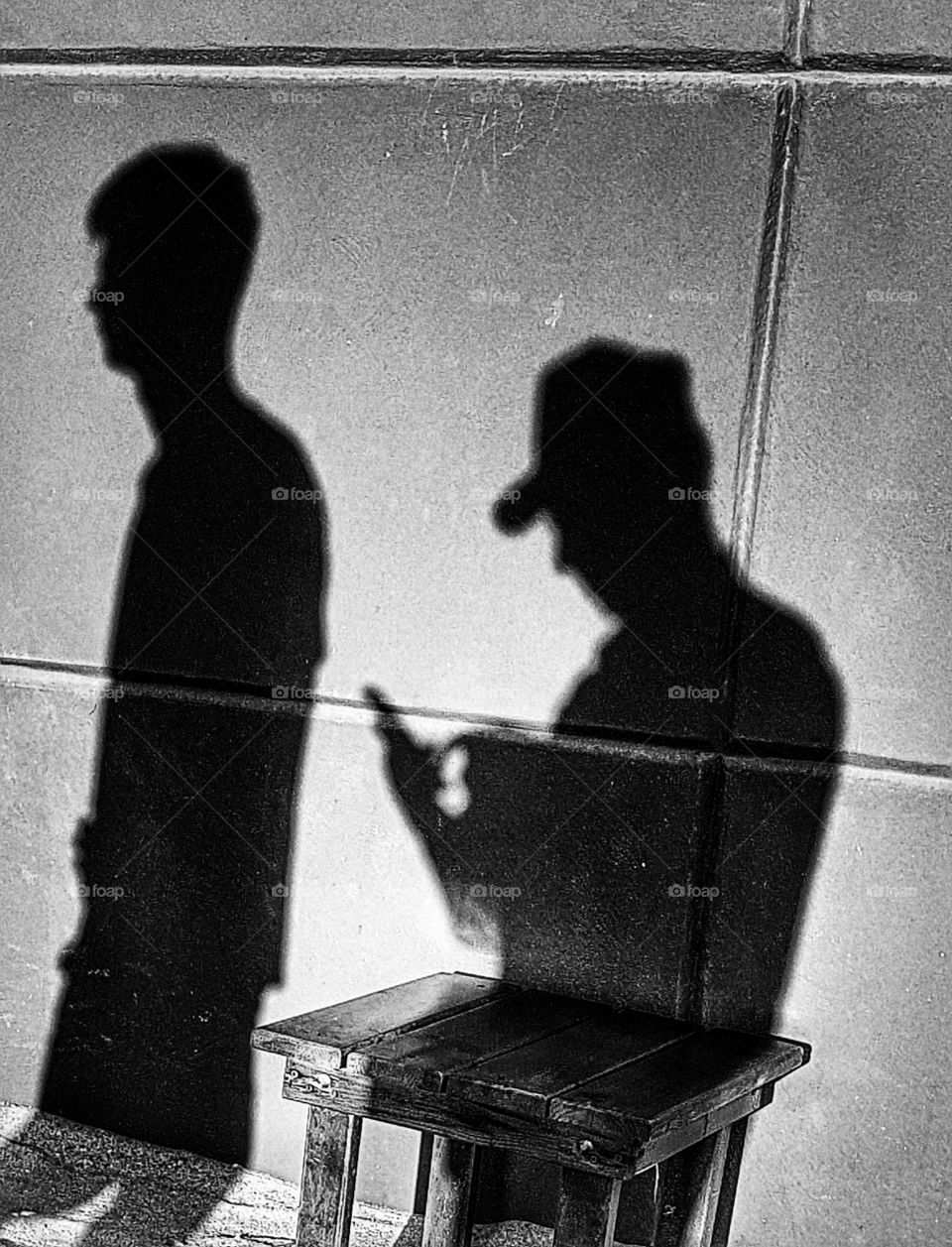 In the shadow  of a taller men.