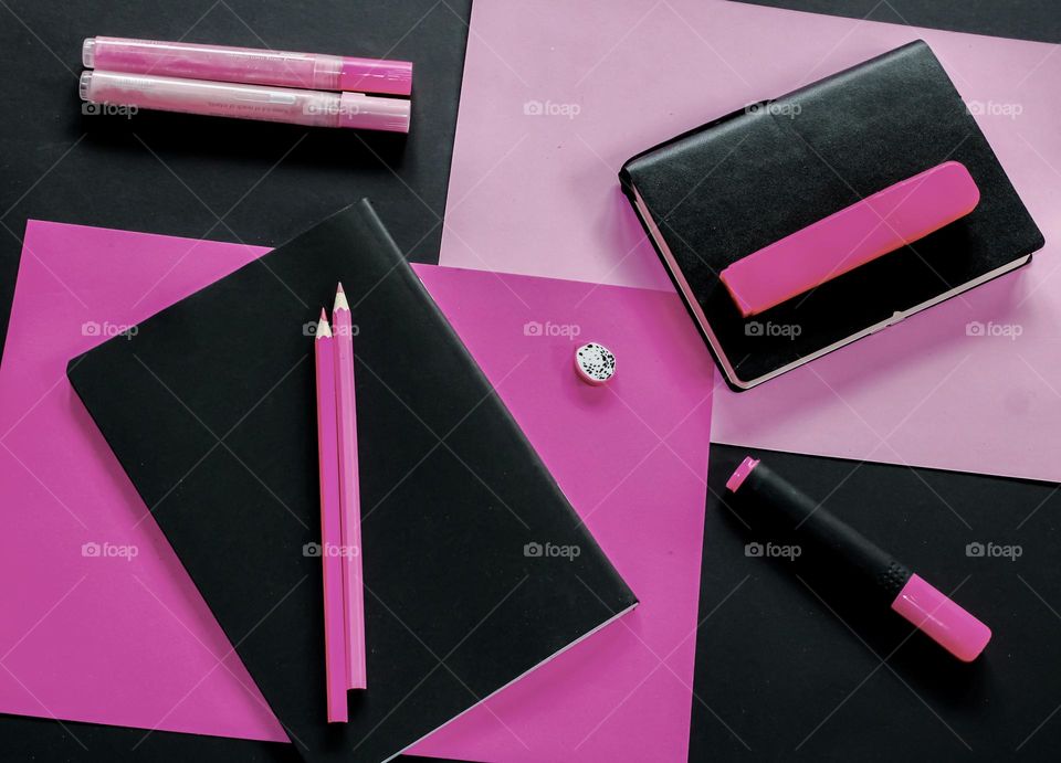 Pink & black stationary flat lay, with notepads, pencils & pens