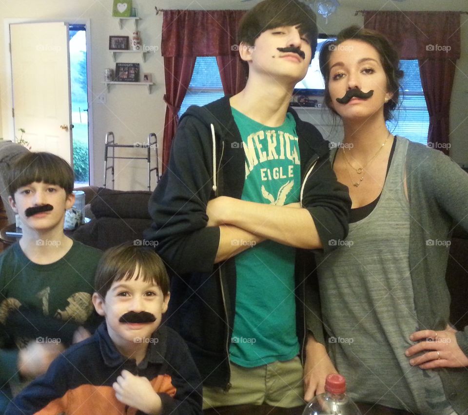 Nephews with their aunt enjoying a bit of fun and posing with mustaches! 