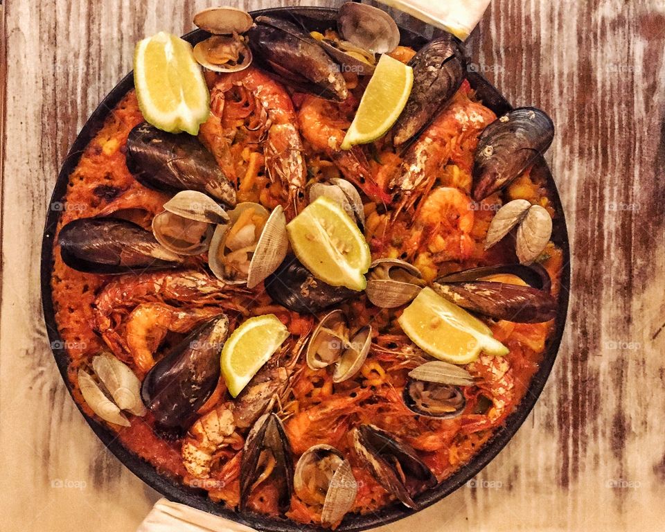 Fresh paella in pan on wooden table