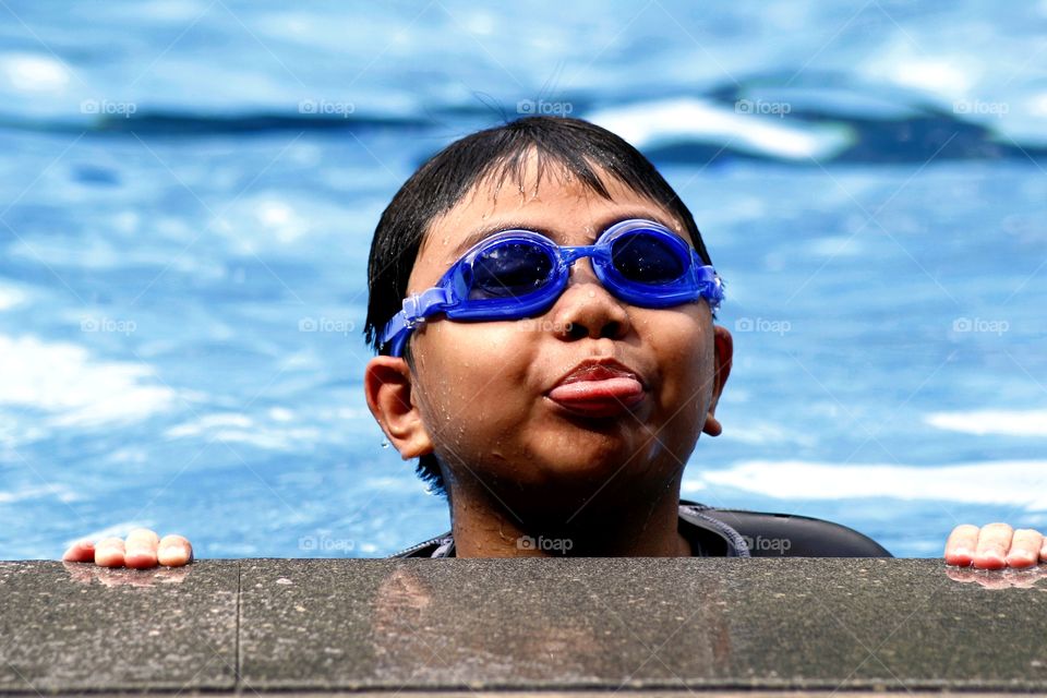 young boy with goggles in a swimming pool