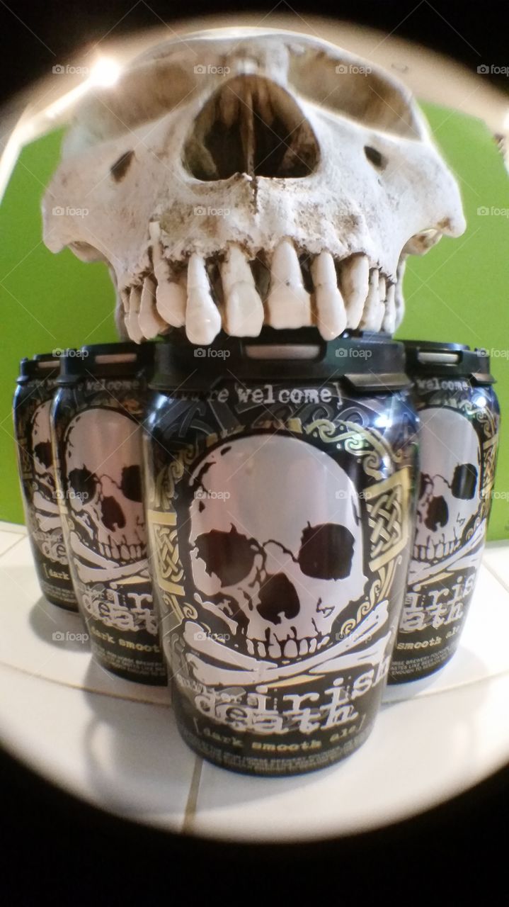 Human skull resting on a six pack.