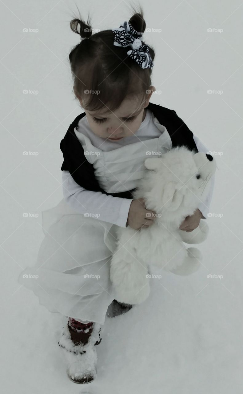 Cute girl standing with toy in winter