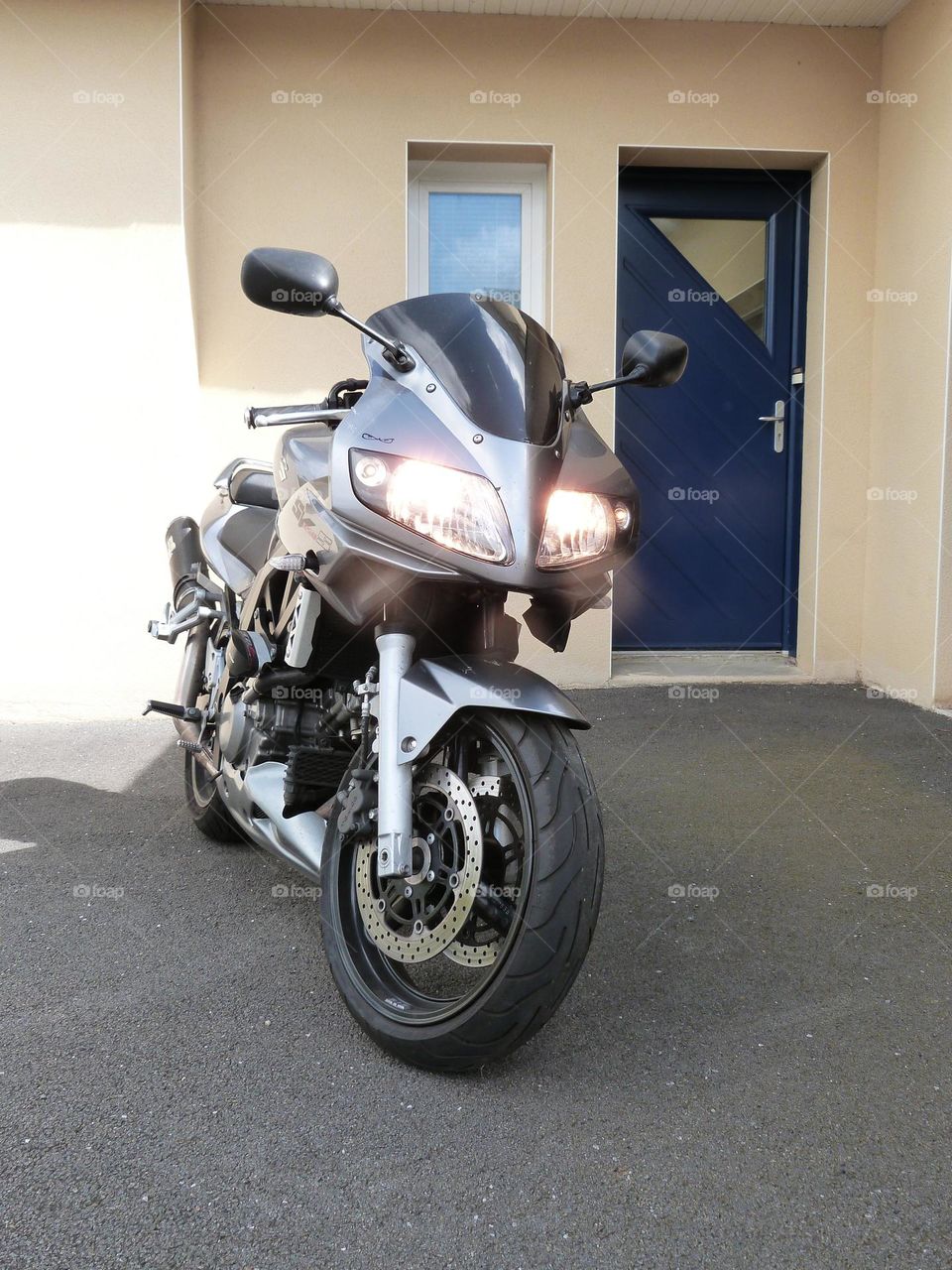 A motorcycle ready to leave its owner's home for a daily commute.