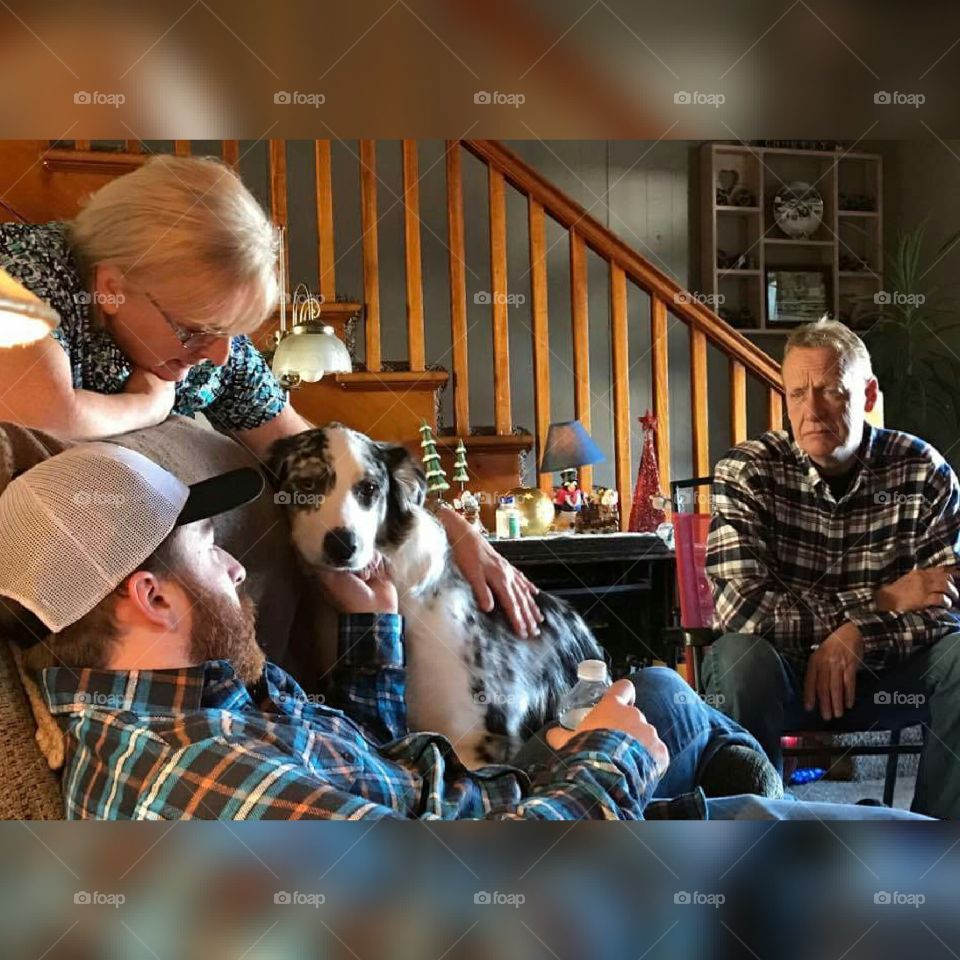 Family sitting with dog at home