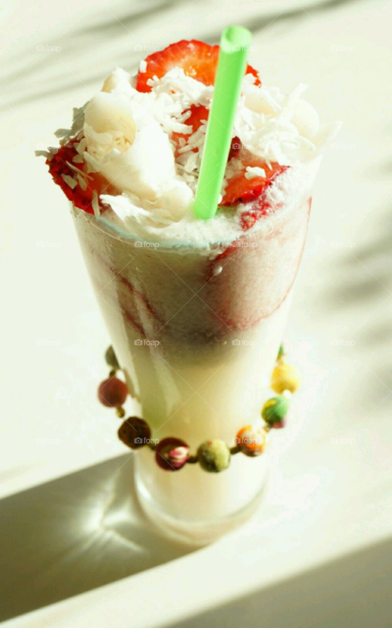 Fresh Fruit smoothie - Young Coconut smoothie topped with slices of strawberries and diced coconut meat