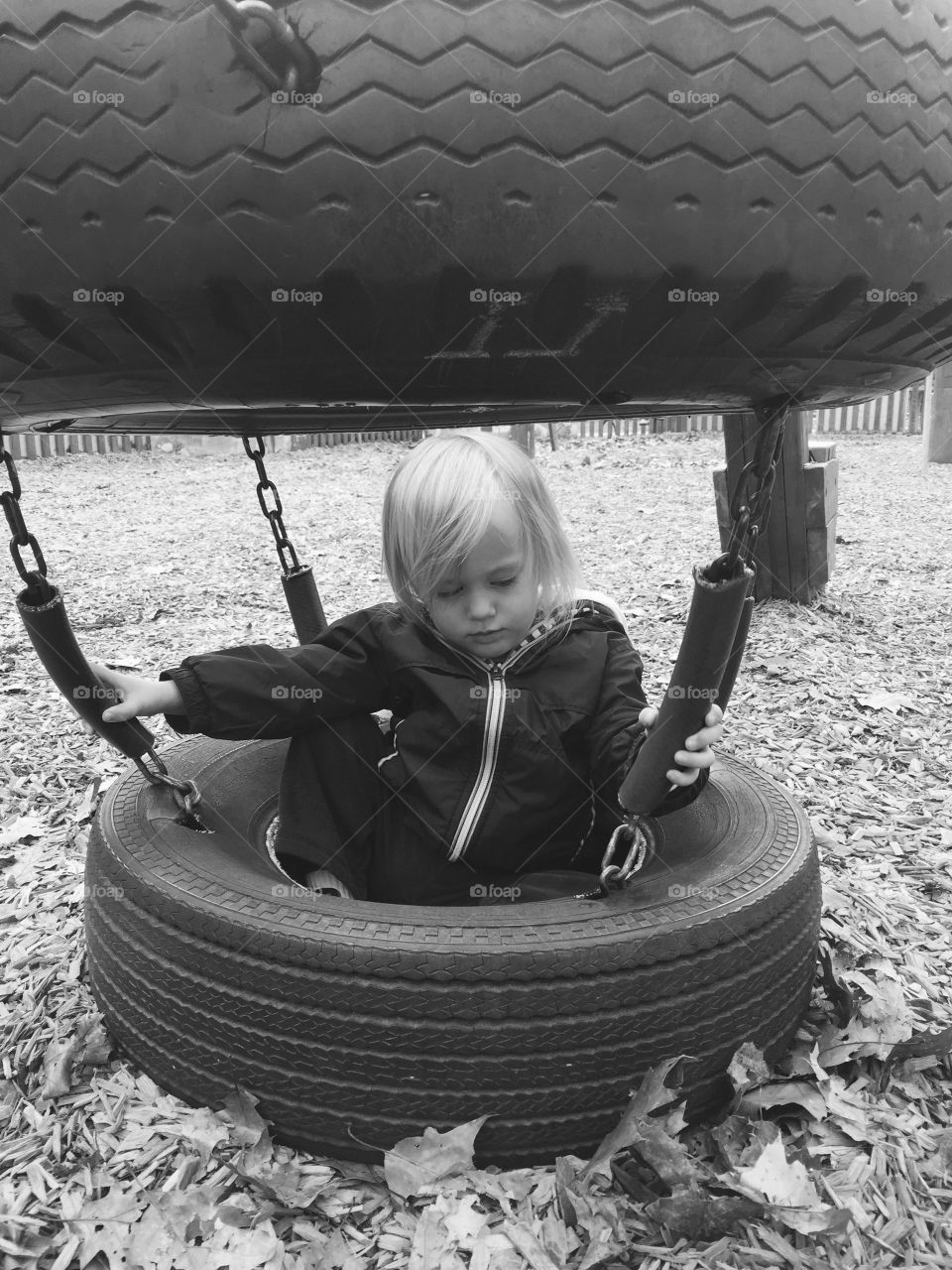 Toddler contemplating life in a tire swing 